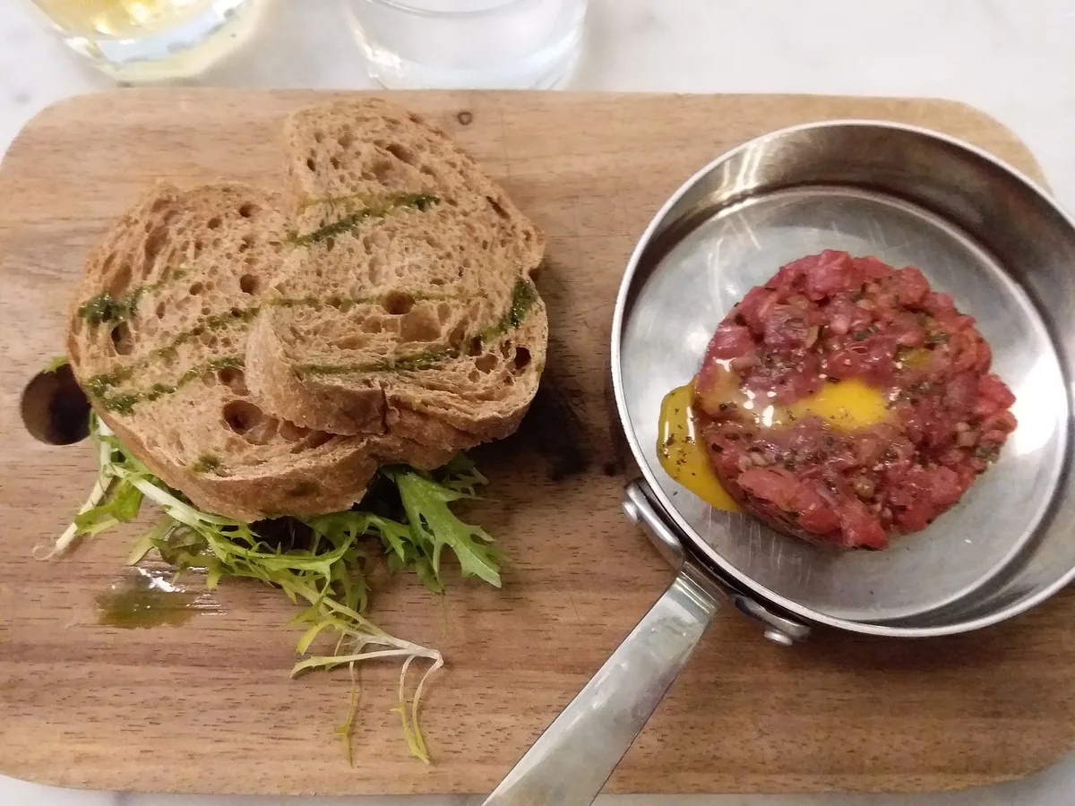 Rustic Estonian dark rye bread and beef tartare on a wooden board